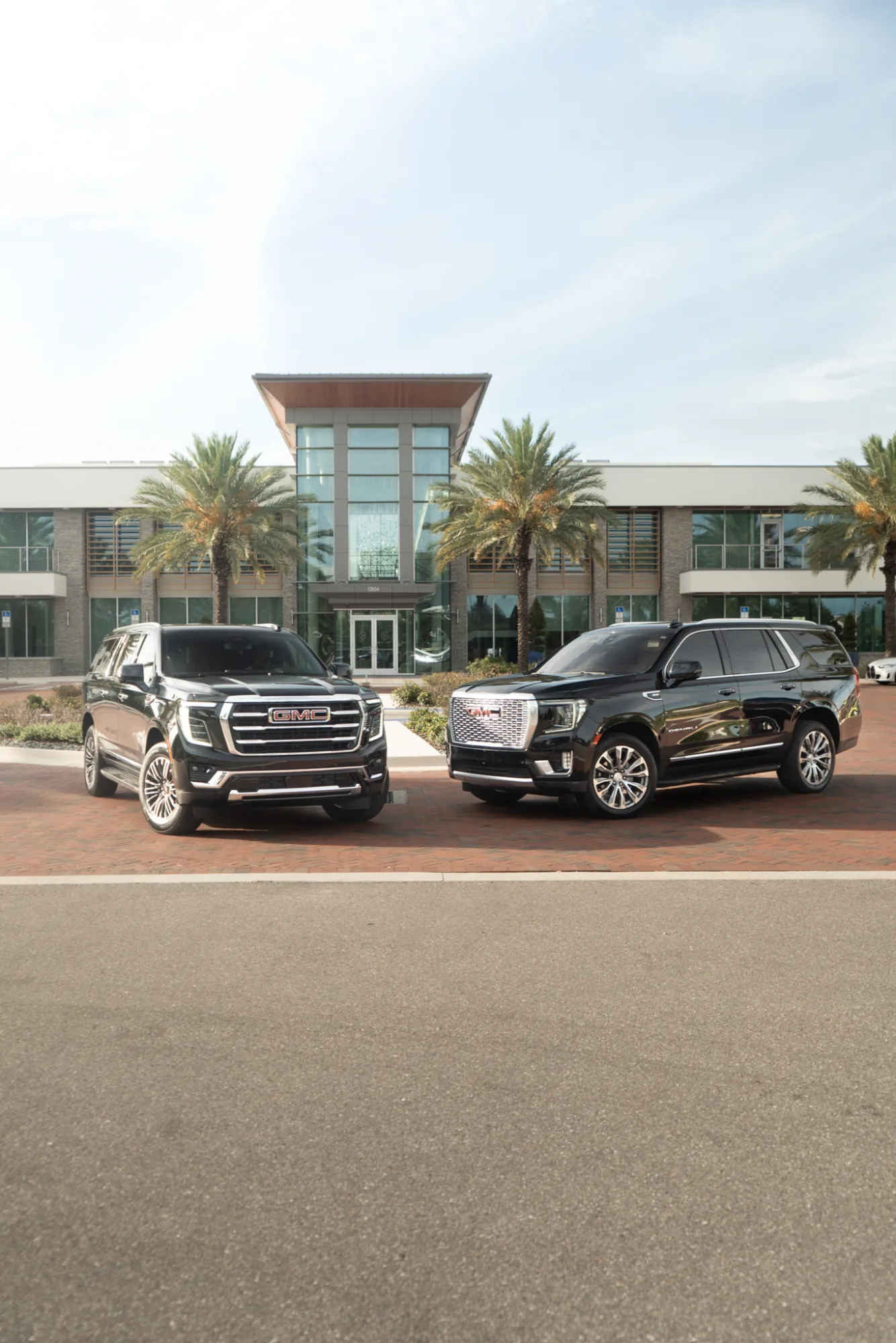 A pair of black GMC luxury SUVs at a three-quarter angle